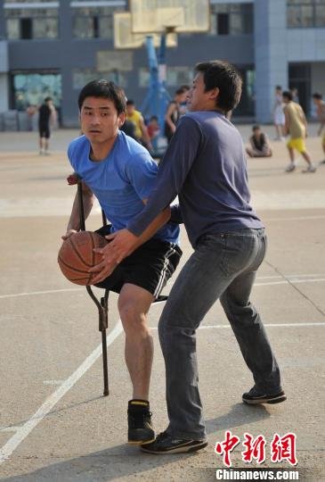 圖為拄著拐杖的瞿詩濤和同學(xué)搶球。劉占昆攝