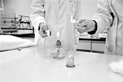 實(shí)驗(yàn)人員操作的燃燒檢測法中，真蠶絲離開火焰就熄滅(左)。