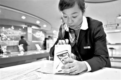 11月6日，北京移動西直門營業(yè)廳的工作人員在為顧客購買的4G手機登記。新華社發(fā)