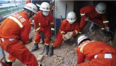 消防人員在清理熔鹽爐倒塌的廢墟。