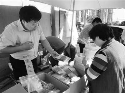 昨日，河南企業(yè)家劉春喜在京“練攤”，為顧客挑選綠豆。新京報記者 張玉學(xué) 攝