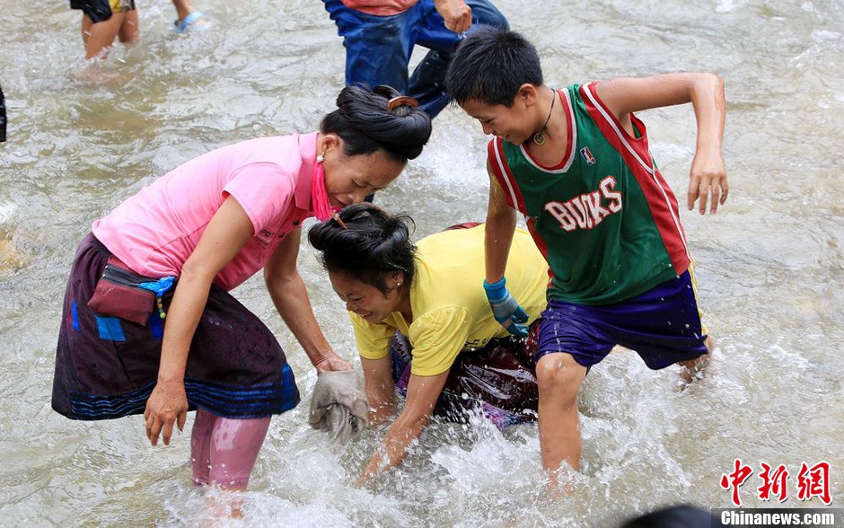 7月9日，村民在小河里摸魚搶魚。譚凱興 攝