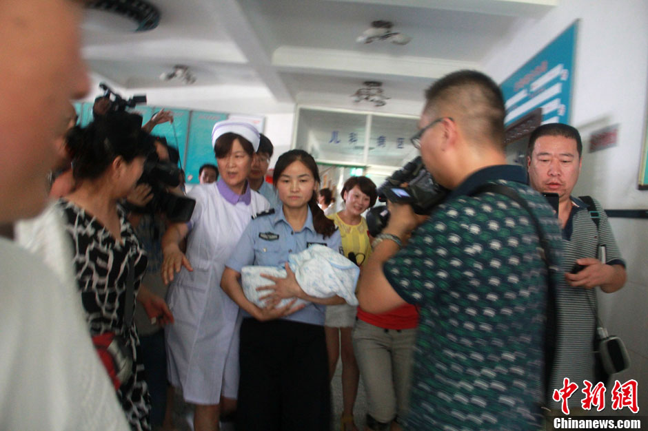 圖為當地民警懷抱獲救嬰兒進入富平婦幼保健院。張一辰 攝