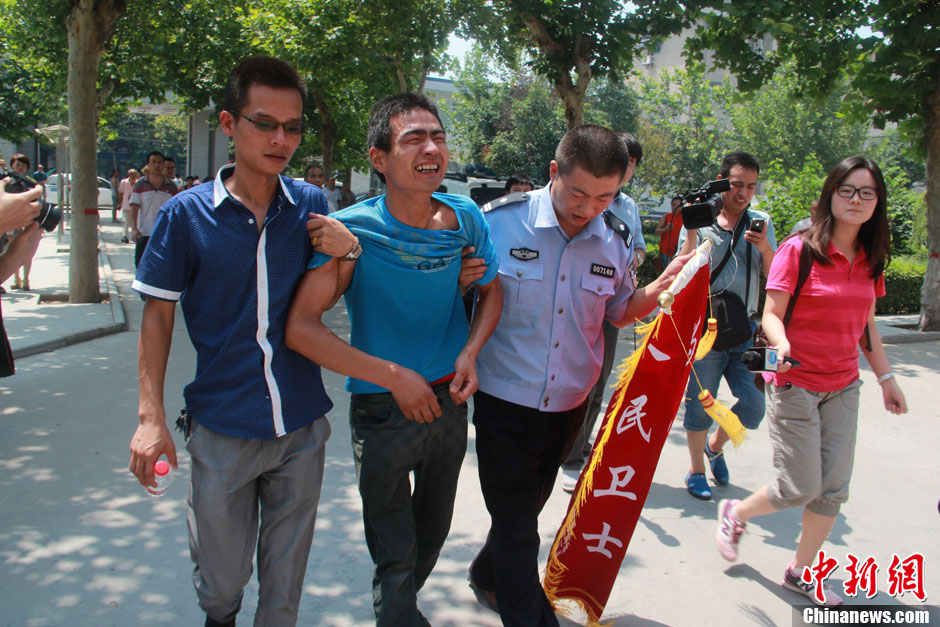 圖為獲救嬰兒父親情緒一度失控，當地警方工作人員對其進行攙扶。張一辰 攝