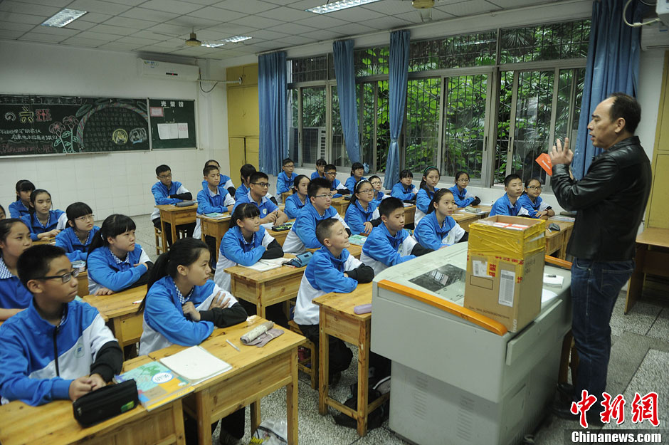 圖為老師正在向同學(xué)們講解用非智能手機(jī)對(duì)他們的好處。