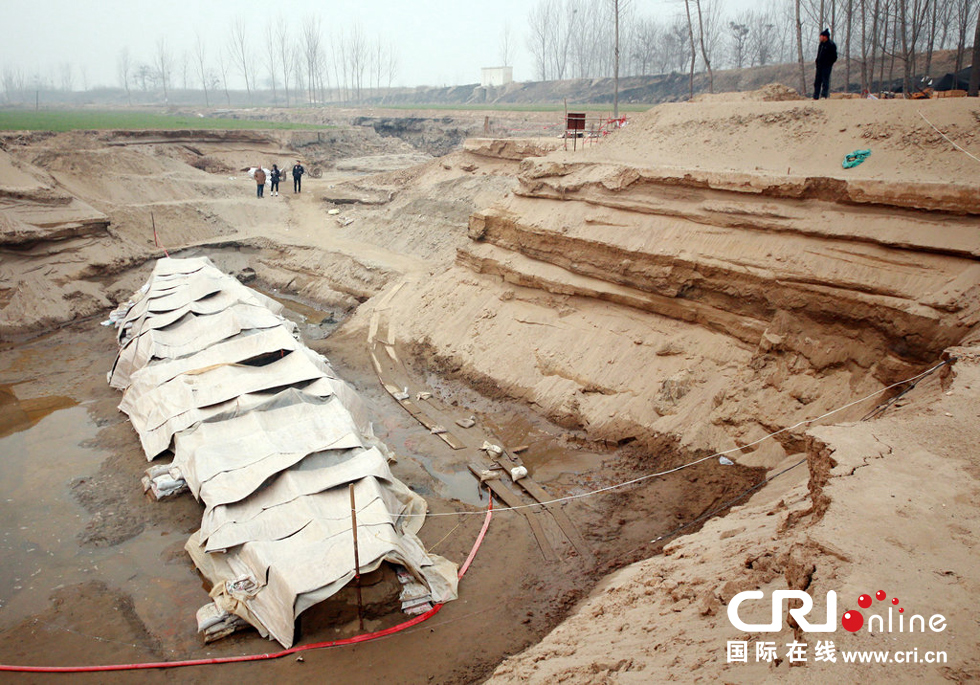 2014年1月6日，河南洛陽古沉船發(fā)掘現(xiàn)場，近日有雨雪天，考古人員給古沉船披上一層“雨衣”。