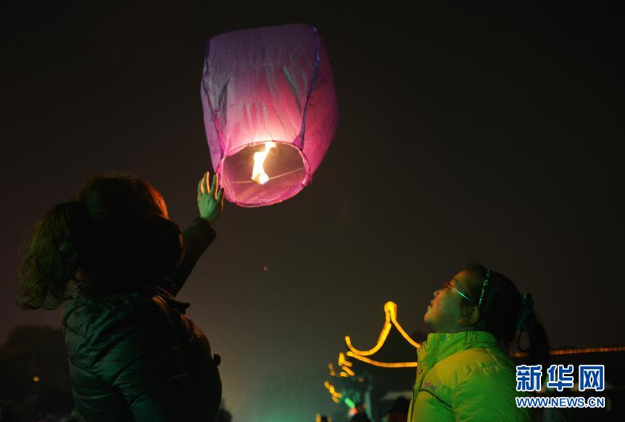 　1月30日，游客在江蘇省鎮(zhèn)江市金山公園門口放飛孔明燈。