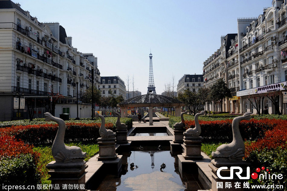 　2014年3月21日，杭州天都城，農(nóng)民在山寨埃菲爾鐵塔下耕作。圖片來源：東方IC