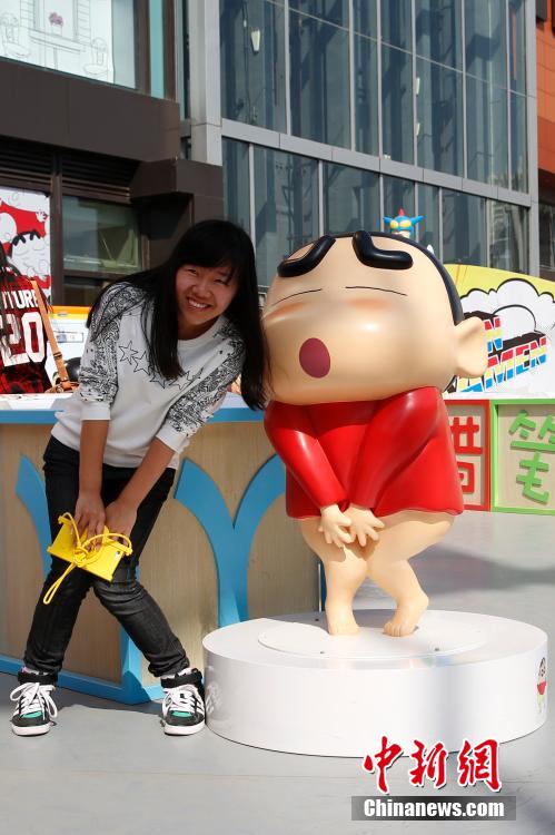 4月22日，游客與蠟筆小新合影。“蠟筆小新25周年紀(jì)念特展”日前在北京開展，吸引了不少市民游客。