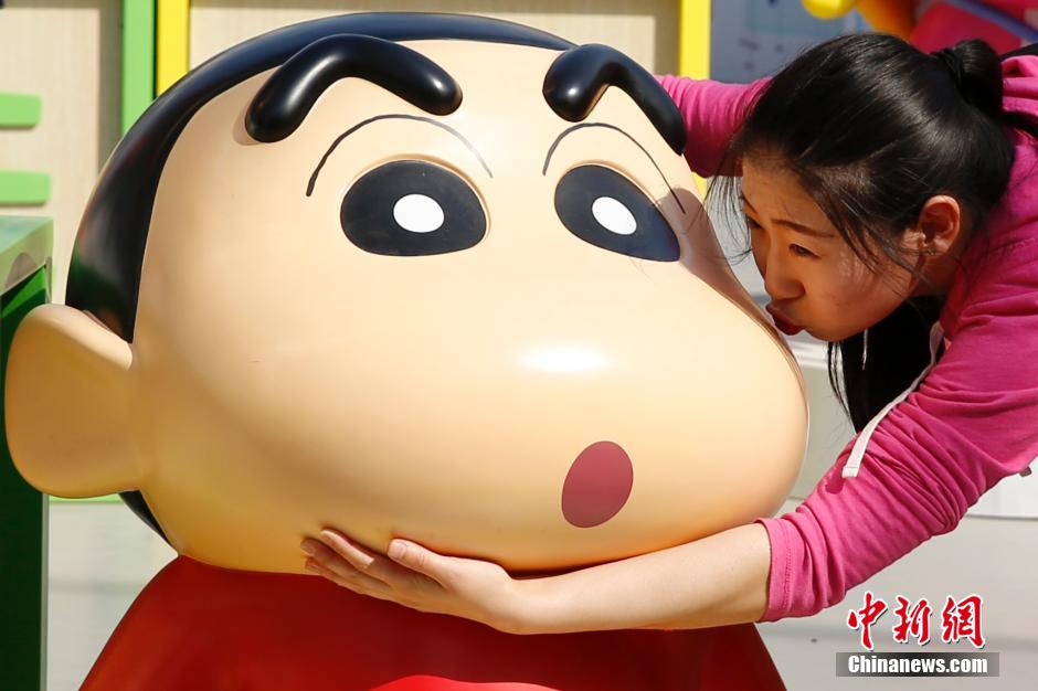 4月22日，游客與蠟筆小新合影。“蠟筆小新25周年紀(jì)念特展”日前在北京開展，吸引了不少市民游客。