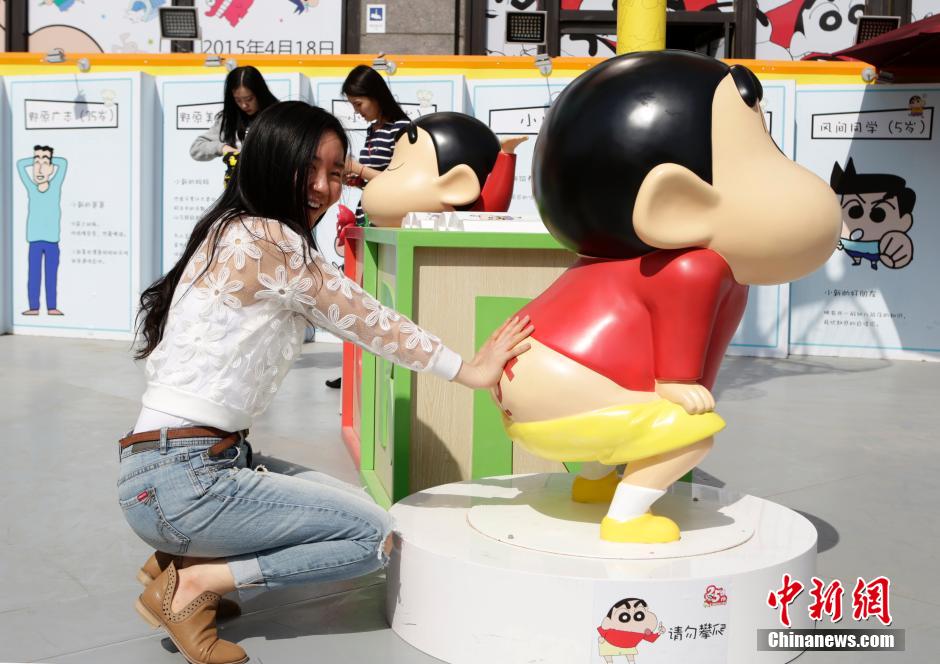 4月22日，游客與蠟筆小新合影?！跋灩P小新25周年紀(jì)念特展”日前在北京開展，吸引了不少市民游客。