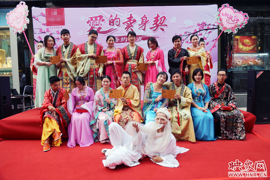 現(xiàn)場(chǎng)8對(duì)兒年輕男女舉起“賣身契”集體拍照。