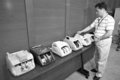 昨日，央行工作人員用各種驗(yàn)鈔機(jī)對C1F9假幣進(jìn)行測試，機(jī)器均能及時作出異常報(bào)警反應(yīng)。新京報(bào)記者 浦