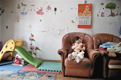 6月14日，未婚媽媽于軍的家里。女兒悅悅抱著兔子玩偶，在聽媽媽手機(jī)上的兒歌，這個(gè)4歲女孩喜歡兔子。