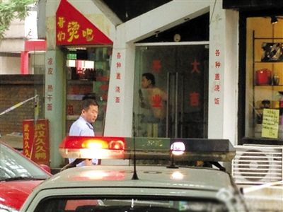 闖入面館的持刀男子與趕來的民警隔著玻璃門對峙，后店內(nèi)一名女童被其劫持。網(wǎng)友供圖