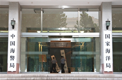 昨日，中國海警局掛牌成立。原國家海洋局和中國海監(jiān)總隊的牌匾被摘下，國家海洋局和中國海警局的新牌匾換上。黃冉 攝