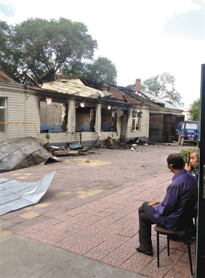 7月27日，海倫聯(lián)合敬老院內(nèi)，幾名老人看著對(duì)面被燒毀的特護(hù)病房。新京報(bào)記者 涂重航 攝