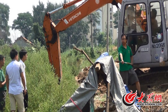 陳寶成手持自制刀斧守在挖掘機(jī)旁阻止便衣民警靠前。駕駛室內(nèi)，張朋珂正向受害人郭曉剛身上澆汽油。（視頻截圖）