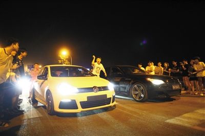 8月24日晚，東壩中街飆車(chē)現(xiàn)場(chǎng)，兩輛車(chē)并排等待出發(fā)指令，旁邊許多愛(ài)好者前來(lái)觀看比賽。新京報(bào)記者