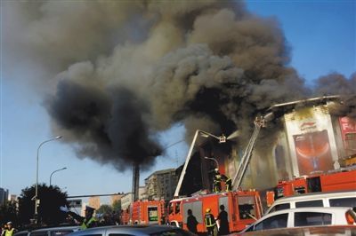 11日，蘋果園喜隆多商場，火災現(xiàn)場濃煙滾滾。新華社發(fā)