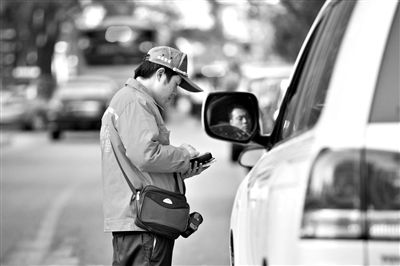 10月15日，朝陽(yáng)區(qū)東大橋路，停車管理員從腰間掏出一個(gè)專用POS機(jī)，正在錄入停車信息。新京報(bào)記者 周崗峰 攝