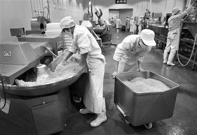 昨日，位于順義李遂開發(fā)區(qū)的慶豐包子鋪配送中心生產(chǎn)車間，工人們正在斬拌胡蘿卜餡料。