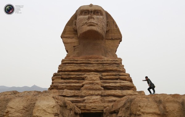 石家莊郊外，一名男子與山寨版獅身人面像合影留念。