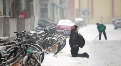 小伙子跪在樓前，一直抬頭看著樓上。 孫立國/攝