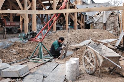 東城區(qū)北鑼鼓巷與小經廠胡同之間一處四合院內，工人進入已經挖好的地下室內施工。