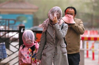 昨日下午，朝陽(yáng)區(qū)豆各莊，行人將紗巾裹在頭上防沙塵。