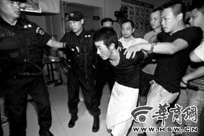 犯罪嫌疑人韓牙某圍著圍裙在廚房?jī)?nèi)拉面，被民警抓獲 本報(bào)記者 鄧小衛(wèi) 攝