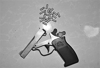 警方從搶劫嫌疑人處起獲的贓款和發(fā)令槍、子彈。警方供圖