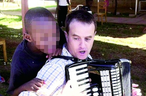 西蒙·伍德在教孩子唱歌，歡樂的歌聲掩蓋不住邪惡的目的。