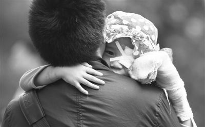 昨日，北京同仁醫(yī)院，被砍傷的彤彤趴在舅舅的肩上。他們剛剛掛完號(hào)，正準(zhǔn)備回旅館。新京報(bào)記者 尹亞飛 攝