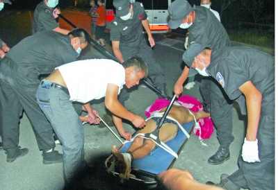 眾人合力將狂犬病發(fā)作的江某控制住。 孫東城 攝