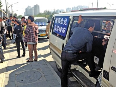 昨日，朝陽區(qū)看守所門前有人排隊。大門外還停有多輛寫有“律師會見”字樣的車。