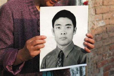 5月19日，朝陽(yáng)北路，母親捧著張東文的遺像。新京報(bào)記者 侯少卿 攝