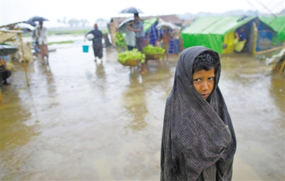 5月14日，緬甸若開邦實(shí)兌難民營(yíng)，羅興亞族難民在雨中行走。熱帶風(fēng)暴“馬哈森”即將登陸緬甸，這里的難民開始乘船撤離。
