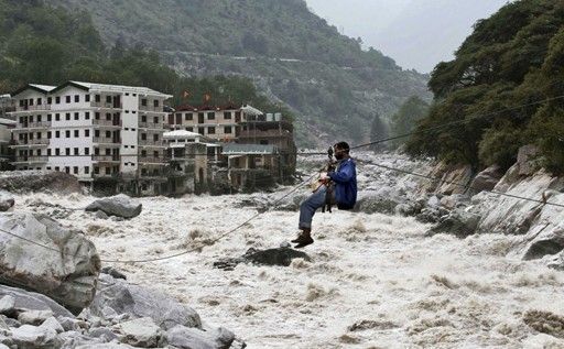 一名印度男子靠繩索渡河。