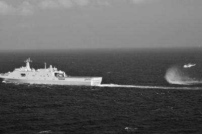 11日，抵達馬航飛機失聯(lián)海區(qū)的海軍井岡山艦與艦載直升機協(xié)同展開立體搜救行動。新華社發(fā)