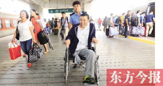 李剛手術(shù)后歸來，在車站工作人員幫助下走出鄭州火車站站臺  東方今報(bào)首席記者 張曉冬 攝