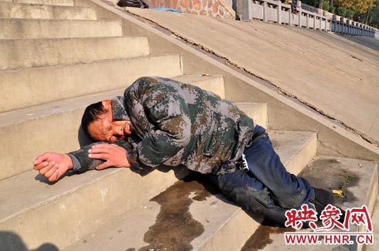 這名男子的衣服以及褲子全濕透了，水從衣褲里流出來，嘴里散發(fā)著濃烈的酒氣。