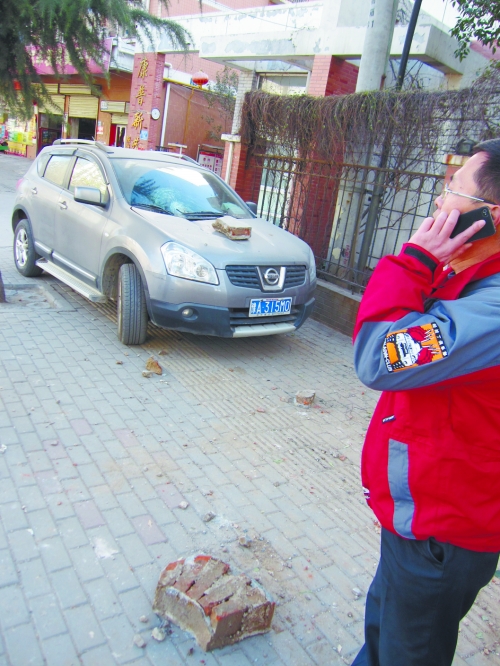 轎車的前引擎蓋上壓著一塊磚塊 轎車的前引擎蓋上壓著一塊磚塊