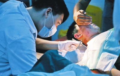 孩子身上有7道傷痕，其中兩道需要縫合，其他的均為擦傷，醫(yī)生正對他施治。