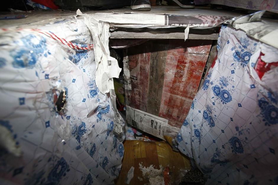 陳小龍?jiān)诔鲎馕萃?，自行又圍起一堵圍墻，安裝了一個(gè)門。圍墻上都是豎起的鐵釘，外面堆著土，鄰居猜是從地底挖出來(lái)的。洞口就在床邊，0.5米見(jiàn)方，深約1.5米。洞口表面一塊紙板掩蓋，打開(kāi)紙板跳入洞底，是一扇小木門，木門外有插銷，可以從外面鎖上。