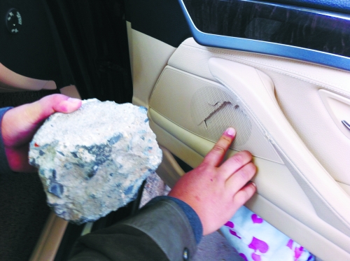 “飛”進寶馬車內(nèi)的大石塊,將寶馬車的車門內(nèi)飾板砸爛。