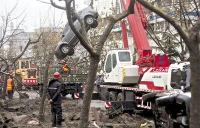 輸油管道爆炸后，搶修人員將被炸毀的車輛運(yùn)出現(xiàn)場。