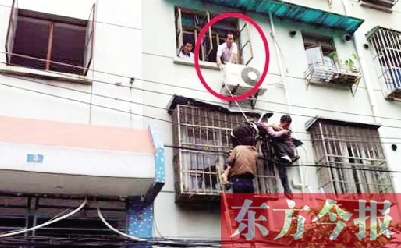 施救現(xiàn)場(chǎng)，劉鵬（圈內(nèi)）先用繩子捆住老太確保安全 勞動(dòng)報(bào)記者 郭娜 供圖