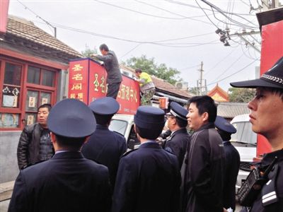 昨日下午,東城區(qū)工商、城管、公安等部門,對雍和宮附近的預(yù)測中心進(jìn)行清理整頓,站在車頂?shù)膬擅と苏鸪患摇邦A(yù)測中心”的招牌。因雍和宮、白云觀等文化景點(diǎn)外聚集大量算命先生,被媒體稱為“算命一條街”。本版攝影/新京報(bào)記者 李寧 攝