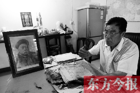 　魏樹紹手拿《物權(quán)法講義》手稿，在講訴先祖書寫“物權(quán)法”的歷史（相框里就是魏聯(lián)奎）